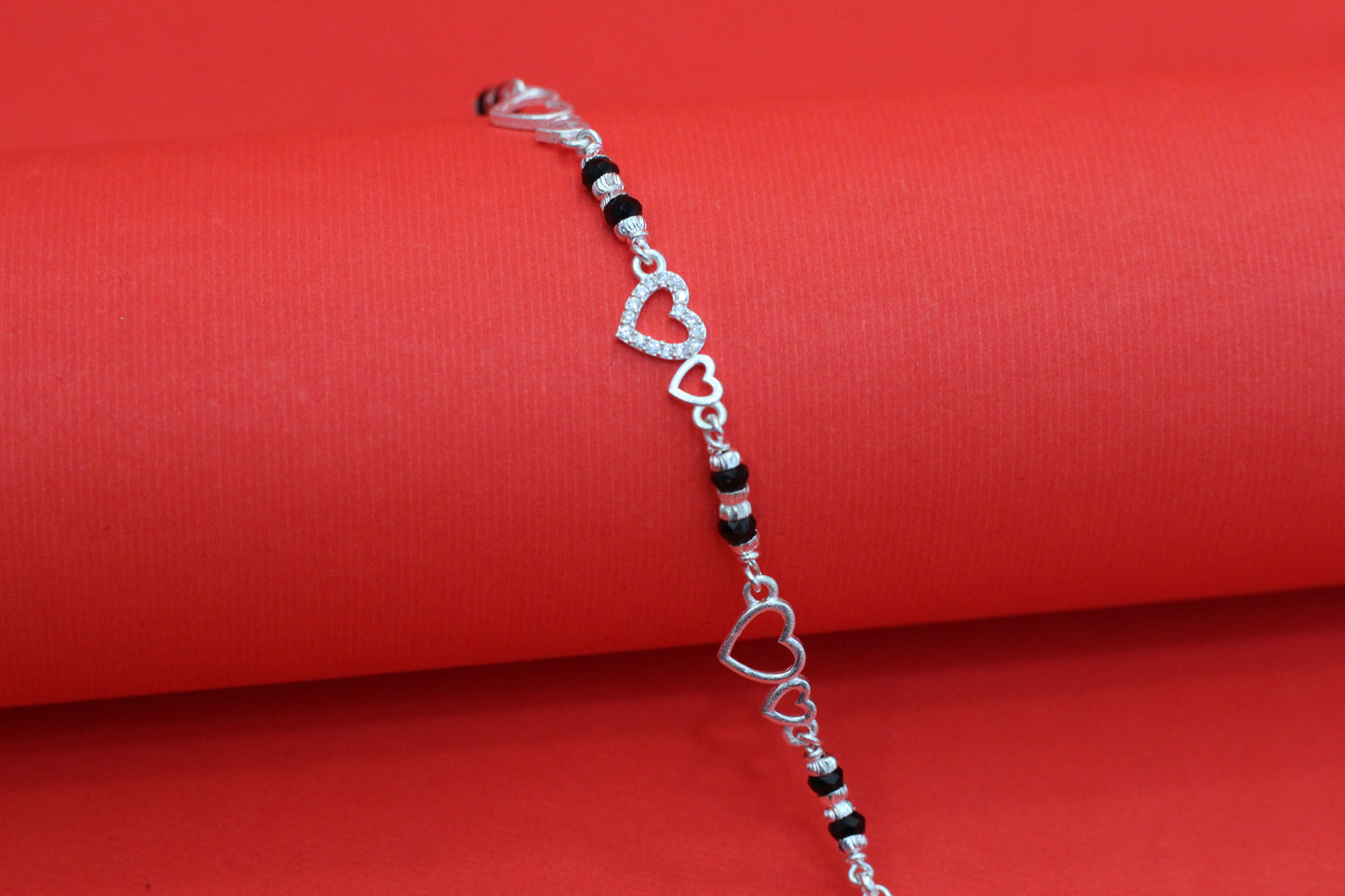 Elegant Silver Interlocking Hearts Bracelet with Black Beads and Cubic Zirconia