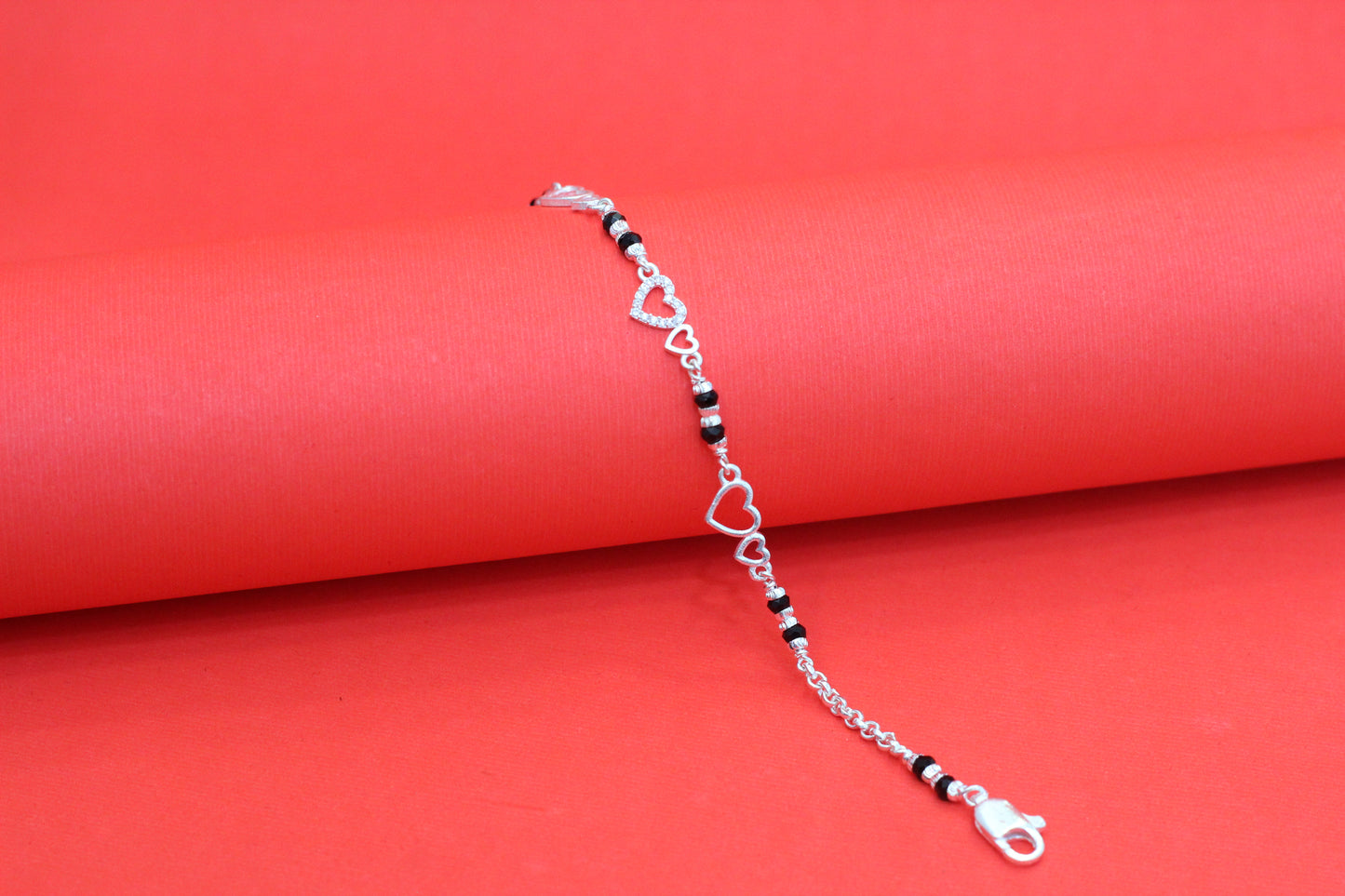 Elegant Silver Interlocking Hearts Bracelet with Black Beads and Cubic Zirconia